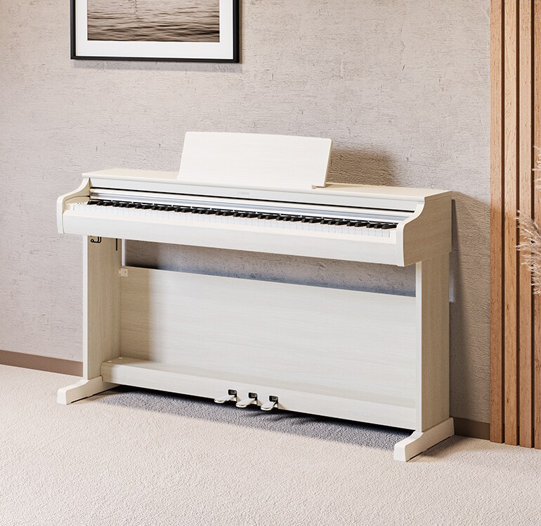 A living room featuring a white birch ARIUS piano with houseplants and a sofa, harmoniously integrated with the interior